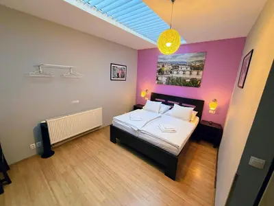 a bedroom with a bed and a desk with a lamp at Central Studios in Prague