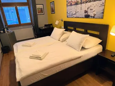 a bedroom with a bed in a room with yellow walls at Central Studios in Prague