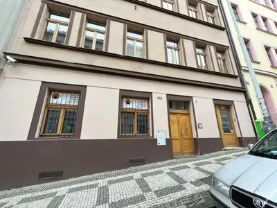 a bedroom with a large bed and a yellow wall at Central Studios in Prague