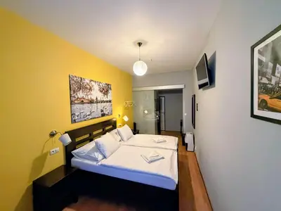 a bedroom with a white bed and a blue wall at Central Studios in Prague