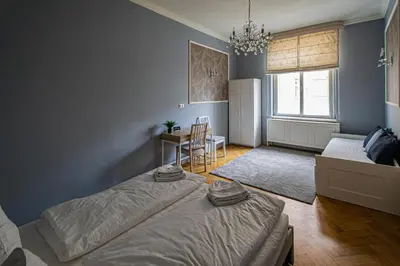 a bedroom with two beds and a table and a chair at Luxury Central 150m2 Apartment on Wencelas Square with Private Garage in Prague