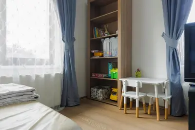 a bedroom with a table and chairs and a book shelf at Guest House KRISTI in Tuchoměřice