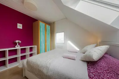 a bedroom with a white bed and pink walls at Guest House KRISTI in Tuchoměřice