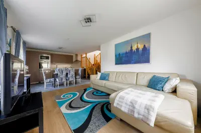 a living room with a couch and a tv at Guest House KRISTI in Tuchoměřice