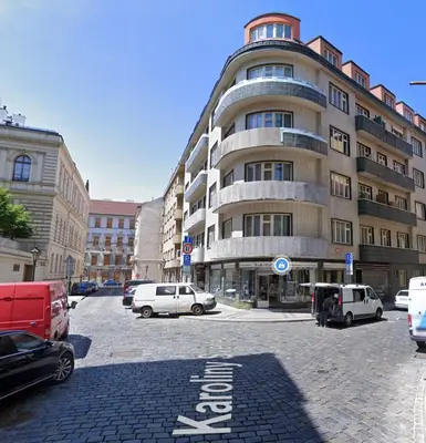 a large building with cars parked in a parking lot at Heart of Old Town Apartment by National Theater in Prague