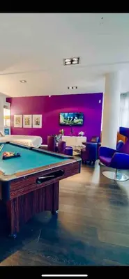 a room with a pool table and purple walls at Miami Lovely romantic Garden apartment with whirlpool in Prague
