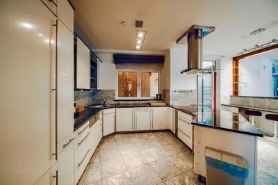 a large kitchen with white cabinets and black counter tops at Miami Lovely romantic Garden apartment with whirlpool in Prague