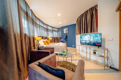 a living room with a couch and a bed and a television at Miami Lovely romantic Garden apartment with whirlpool in Prague