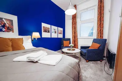 a blue bedroom with a bed and a chair at Unique apartment with private pool, cinema, SPA in Prague