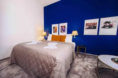 a bedroom with a large bed with a blue wall at Unique apartment with private pool, cinema, SPA in Prague