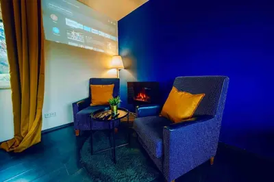 a living room with two chairs and a fire place at Lovely 3BD - Rooftop - Jacuzzi&Sauna in Prague