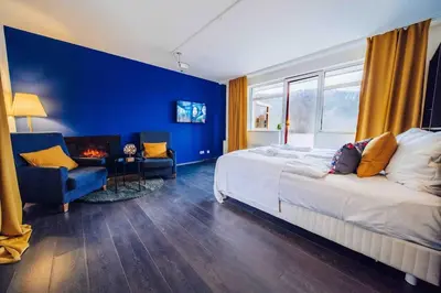 a bedroom with a bed and a blue wall at Lovely 3BD - Rooftop - Jacuzzi&Sauna in Prague