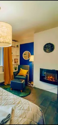 a room with a bed and a chair and a fireplace at Lovely 3BD - Rooftop - Jacuzzi&Sauna in Prague