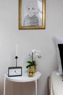 a table with a candle and a picture on a wall at Golden Tree Loft in the Heart of Prague in Prague