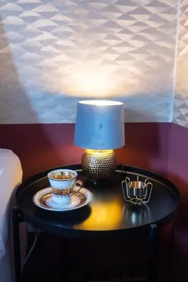 a table with a lamp and a cup on it at Golden Tree Loft in the Heart of Prague in Prague