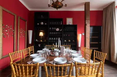 a dining room table with chairs and a red wall at Golden Tree Loft in the Heart of Prague in Prague