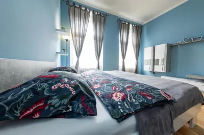 a bedroom with blue walls and a bed with two pillows at I.P.Pavlova in Prague
