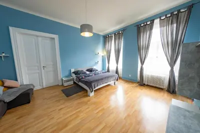 a bedroom with blue walls and a bed in front of a window at I.P.Pavlova in Prague