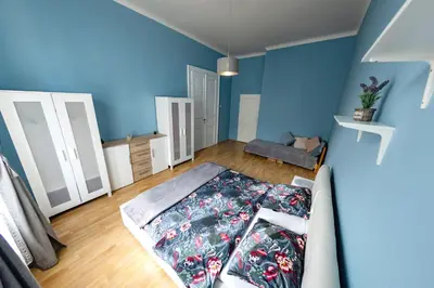 a room with a bed and a blue wall at I.P.Pavlova in Prague