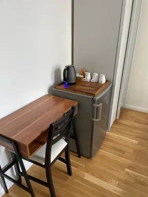 a small kitchen with a wooden table and a table and chair at Prague National Museum Apartment in Prague