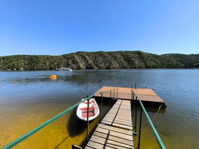 a boat tied to a dock on a lake at ZÁTOKA Živohošť - Chaty in Chotilsko