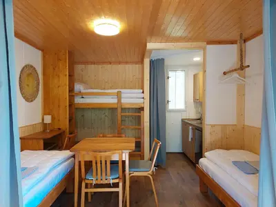 a room with two bunk beds and a table and chairs at ZÁTOKA Živohošť - Chaty in Chotilsko