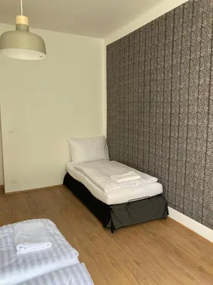 a room with two beds and a wall at Žižkov tower suites in Prague