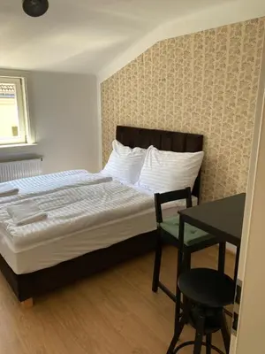 a bedroom with a bed and a table and a desk at Žižkov tower suites in Prague