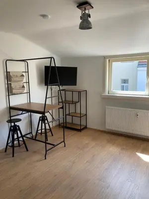 a room with a desk and a table and a window at Žižkov tower suites in Prague