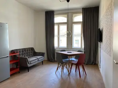a living room with a table and a couch at Žižkov tower suites in Prague
