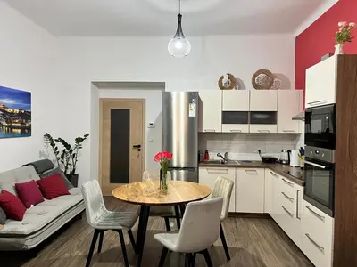 a kitchen and living room with a table and a couch at PRAGUE’s HIDDEN PEARL in Prague