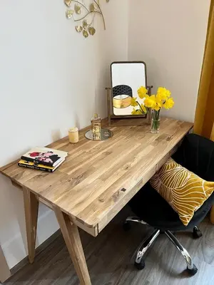 a wooden desk with a vase of flowers and a mirror at PRAGUE’s HIDDEN PEARL in Prague