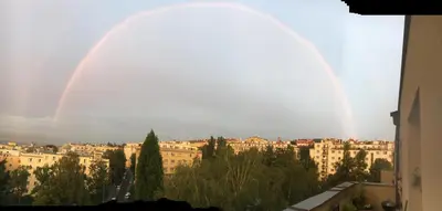 a double rainbow over a city with buildings at Kiki & Luky family apartment by Prague Castle in Prague
