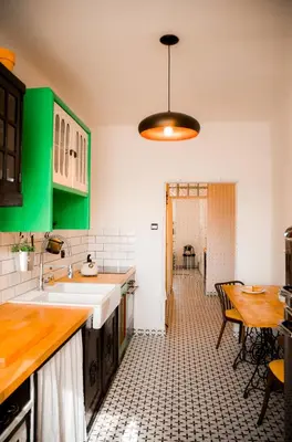 a kitchen with green cabinets and a table and a table at Kiki & Luky family apartment by Prague Castle in Prague