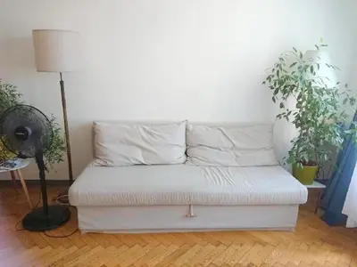 a white couch sitting in a room with plants at Cozy studio in the heart of old Prague near the Charles Bridge in Prague