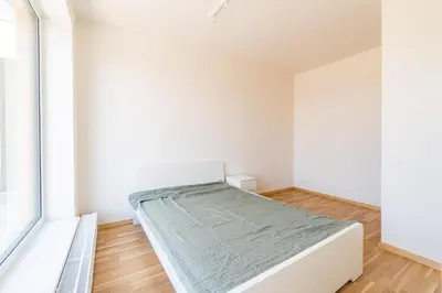 a bedroom with a bed and a window at Penthouse # 81 with panoramic city view in Elite Rezidence with free parking in Prague