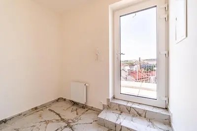 an empty room with a window and marble floor at Penthouse # 81 with panoramic city view in Elite Rezidence with free parking in Prague