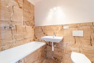 a bathroom with a sink and a tub and a toilet at Penthouse # 81 with panoramic city view in Elite Rezidence with free parking in Prague