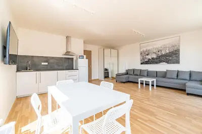 a kitchen and living room with a white table and chairs at Penthouse # 81 with panoramic city view in Elite Rezidence with free parking in Prague
