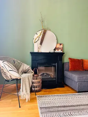a living room with a chair and a fireplace at Black Pearl by Vysehrad Castle in Prague