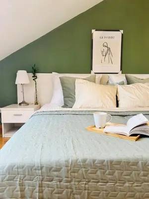 a bedroom with a large bed with a book and a coffee cup on it at Black Pearl by Vysehrad Castle in Prague