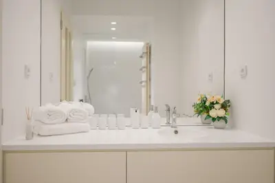 a white bathroom with a sink and a mirror at Prague Days - City Central One-bedroom Apartment right next to Old Town Square in Prague