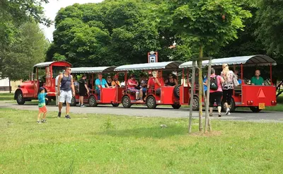 a group of people riding on a red train at Apartmá v srdci Poděbrad in Poděbrady