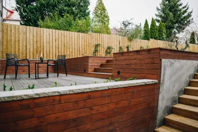 a backyard with a wooden fence and a table and chairs at Executive Apartments Taborska in Mladá Boleslav