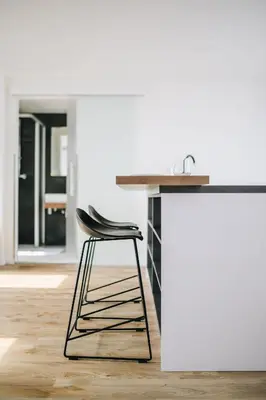 a kitchen with a counter with a black stool at Executive Apartments Taborska in Mladá Boleslav