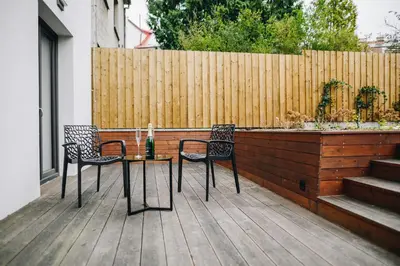 a table and chairs on a deck with a fence at Executive Apartments Taborska in Mladá Boleslav
