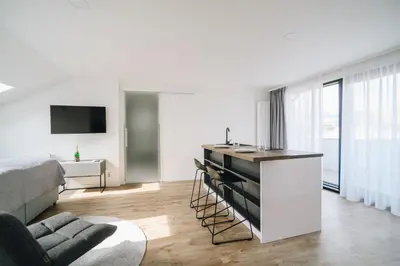 a white apartment with a kitchen and a living room at Executive Apartments Taborska in Mladá Boleslav