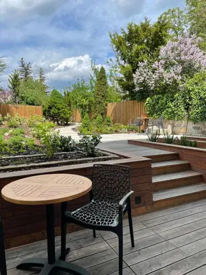 a wooden table and chair on a patio with stairs at Executive Apartments Taborska in Mladá Boleslav