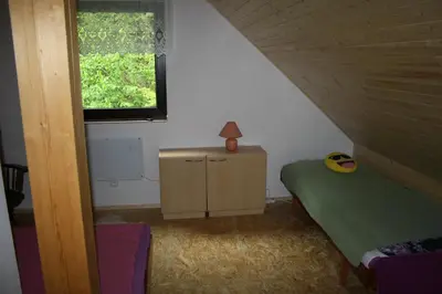 a small bedroom with a bed and a window at Chata na řece Sázavě in Samopše