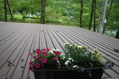 a bunch of flowers sitting on a wooden deck at Chata na řece Sázavě in Samopše